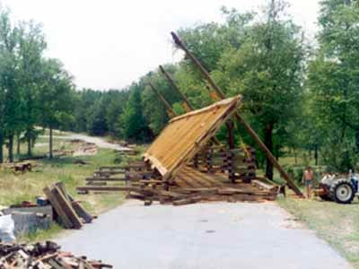 Timber bridge frame being raised on falsework in open field during construction