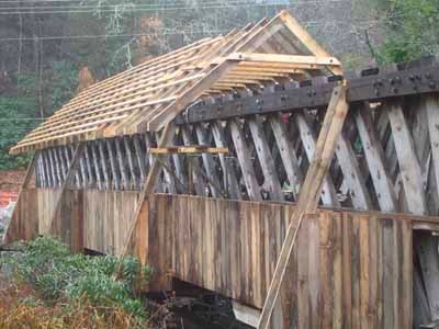 William Henry Stevens bridge completed with new white metal roof spanning creek