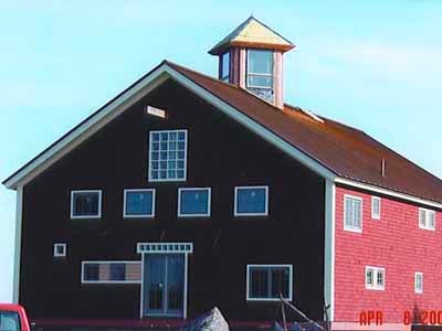 Completed Garner barn with black and red exterior and cupola